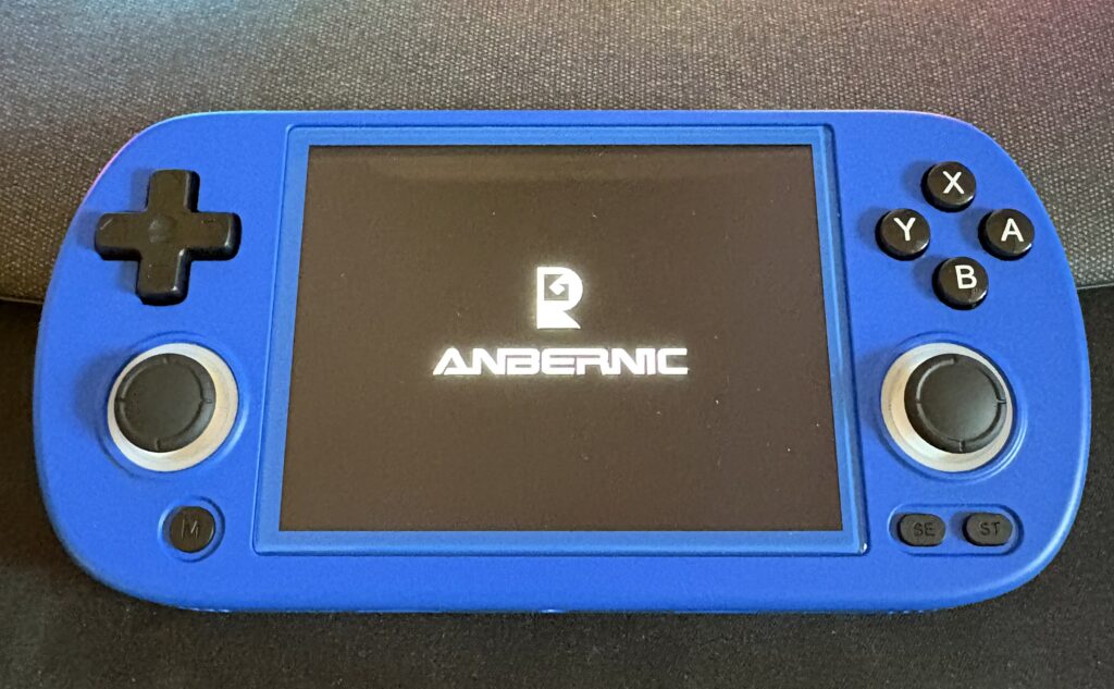Console per videogiochi portatile Anbernic blu, accesa con il logo visibile sullo schermo.