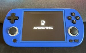 Console per videogiochi portatile Anbernic blu, accesa con il logo visibile sullo schermo.